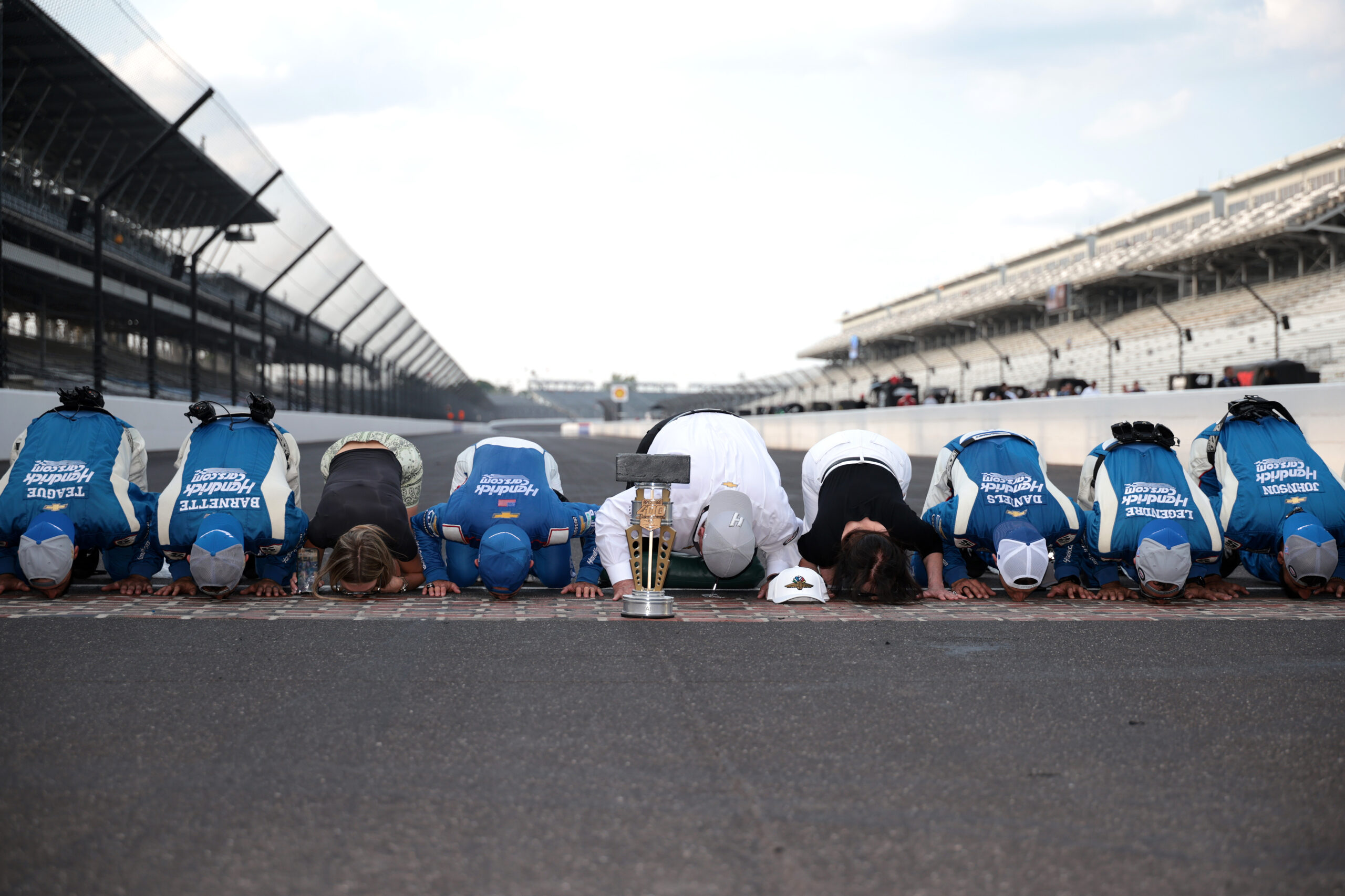 Kyle Larson kisses the bricks at Indianapolis Motor Speedway